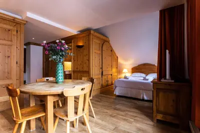 a bedroom with a table with a vase of flowers on it at Les Balcons du Savoy in Chamonix-Mont-Blanc