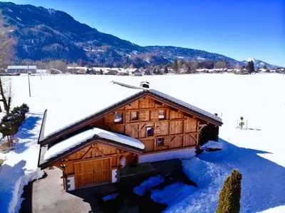 a log cabin with snow on the roof at Chalet Pétérets in Samoëns