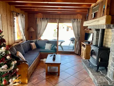 a living room with a couch and a christmas tree at Chalet Pétérets in Samoëns