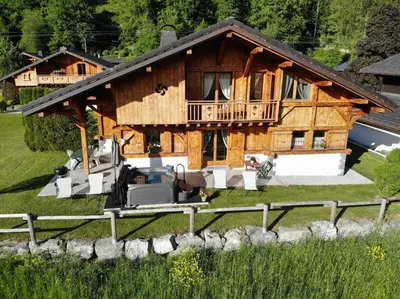 a large wooden house with a porch and a balcony at Chalet Pétérets in Samoëns