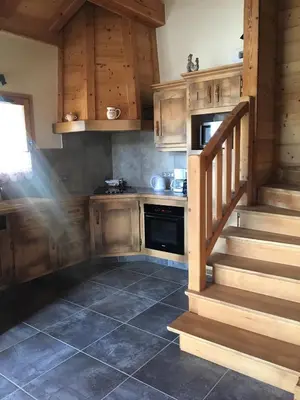 a kitchen with wooden cabinets and stairs in a kitchen at Chalet Clos Moccand in Samoëns