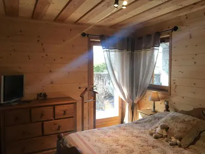 a bedroom with a bed and a television and a window at Chalet Clos Moccand in Samoëns