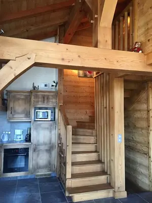 a staircase leading up to a kitchen in a log cabin at Chalet Clos Moccand in Samoëns