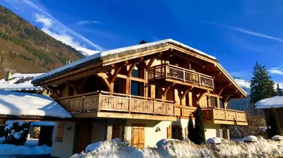 a log cabin with a balcony in the snow at Chalet Clos Moccand in Samoëns