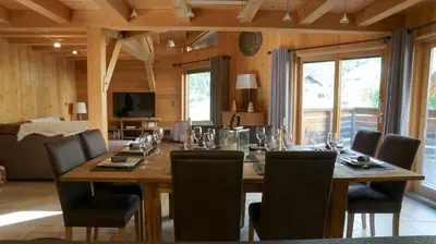 a dining room with a large wooden table and chairs at LES 3 CIMES BLANCHES in Chamonix-Mont-Blanc