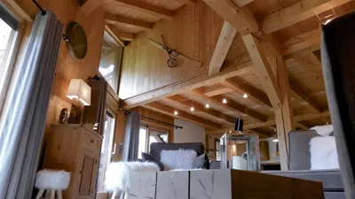 a tiny house with a wooden ceiling and a chair at LES 3 CIMES BLANCHES in Chamonix-Mont-Blanc