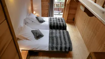 a bedroom with two beds in a wooden cabin at LES 3 CIMES BLANCHES in Chamonix-Mont-Blanc