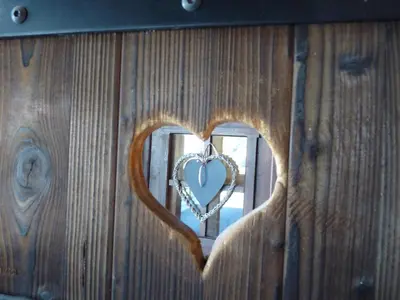 a heart shaped mirror on a wooden wall at LES 3 CIMES BLANCHES in Chamonix-Mont-Blanc
