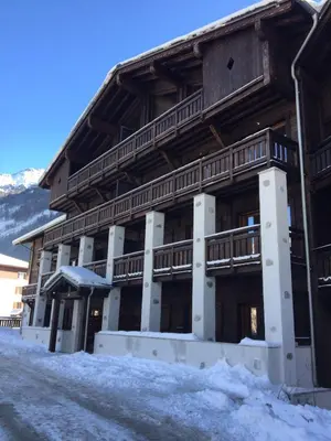 a large wooden building with snow in front of it at Grand Paradis in Chamonix-Mont-Blanc