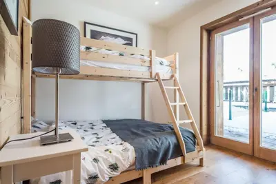 a bunk bed in a room with a desk and a lamp at Grand Paradis in Chamonix-Mont-Blanc