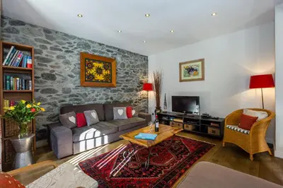 a living room with a couch and a tv at Lodge aux Praz in Chamonix-Mont-Blanc