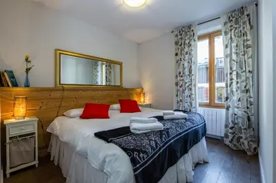 a bedroom with two beds with red pillows and a mirror at Lodge aux Praz in Chamonix-Mont-Blanc