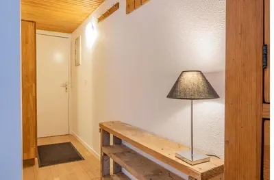 a lamp sitting on a wooden bench in a room at Apartment Triolet Jardin - Garden with Mont Blanc Views in Chamonix-Mont-Blanc