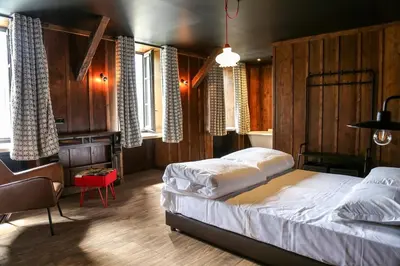 a bedroom with a bed and a desk and windows at Refuge du Montenvers in Chamonix-Mont-Blanc