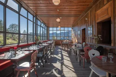 a restaurant with tables and chairs and windows at Refuge du Montenvers in Chamonix-Mont-Blanc