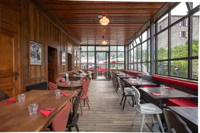 a restaurant with wooden tables and chairs and windows at Refuge du Montenvers in Chamonix-Mont-Blanc