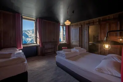 a bedroom with two beds and a large window at Refuge du Montenvers in Chamonix-Mont-Blanc
