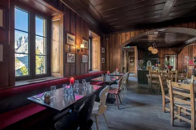 a dining room with tables and chairs and windows at Refuge du Montenvers in Chamonix-Mont-Blanc