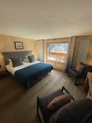 a bedroom with a large bed and a television at Auberge du Bois Prin in Chamonix-Mont-Blanc