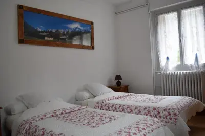 two beds in a bedroom with a picture on the wall at Résidence Le Fontenay in Plateau dʼAssy