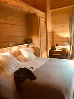 a bedroom with a large white bed with wooden walls at Le Cerf Amoureux Chalet Privé & Spa in Sallanches