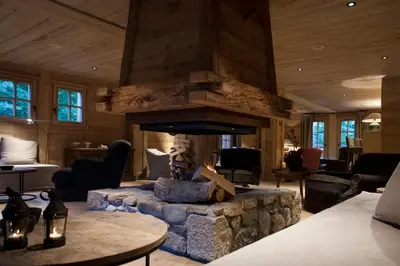 a living room with a stone fire place at Le Cerf Amoureux Chalet Privé & Spa in Sallanches