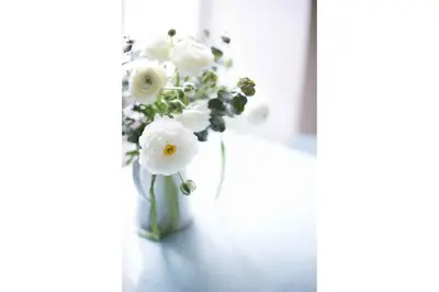 a vase filled with white flowers sitting on a table at Appartement Cocon in Chamonix-Mont-Blanc