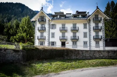 a large white building with balconies on a wall at Appartement Cocon in Chamonix-Mont-Blanc