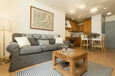 a living room with a couch and a table at Apartment Balme 2 - Central Chamonix Haven and Mont Blanc View in Chamonix-Mont-Blanc