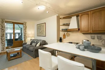 a kitchen and living room with a couch and a table at Apartment Balme 2 - Central Chamonix Haven and Mont Blanc View in Chamonix-Mont-Blanc