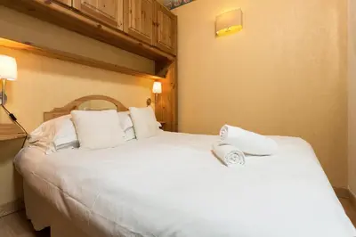 a bedroom with a large white bed with towels on it at Apartment Balme 2 - Central Chamonix Haven and Mont Blanc View in Chamonix-Mont-Blanc