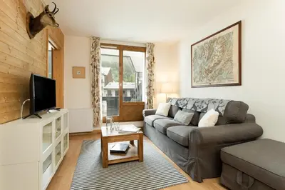 a living room with a couch and a tv at Apartment Balme 2 - Central Chamonix Haven and Mont Blanc View in Chamonix-Mont-Blanc