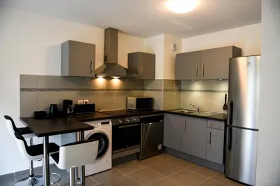a kitchen with a refrigerator and a counter top at Appartement au pied du Mont-Blanc ! in Sallanches