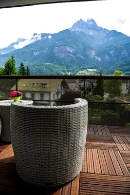 a balcony with a table and a view of mountains at Appartement au pied du Mont-Blanc ! in Sallanches