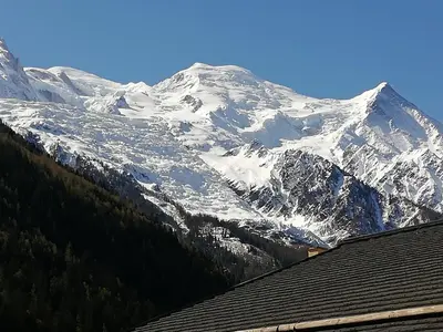 a snow covered mountain in front of a house at Champalo in Chamonix-Mont-Blanc