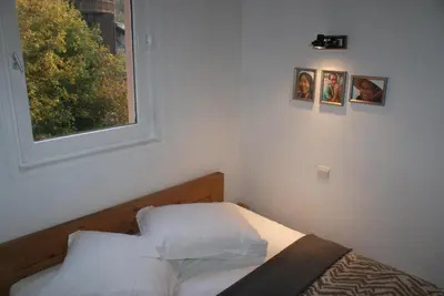 a bedroom with a bed with white sheets and a window at Champalo in Chamonix-Mont-Blanc