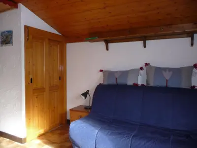 a bedroom with a blue bed and a wooden ceiling at Résidence Les Jorasses in Servoz