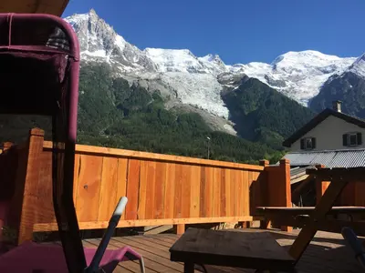 a wooden deck with a view of a snow covered mountain at La Para in Chamonix-Mont-Blanc