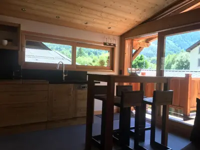 a kitchen with a table and some chairs and windows at La Para in Chamonix-Mont-Blanc