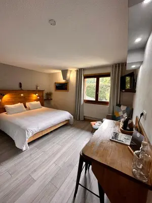 a hotel room with a bed and a desk at Fontaine du Mont Blanc Hotel & Spa in Les Houches