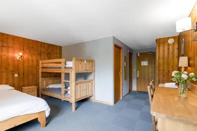 a bedroom with a bunk bed and a desk at Fontaine du Mont Blanc Hotel & Spa in Les Houches