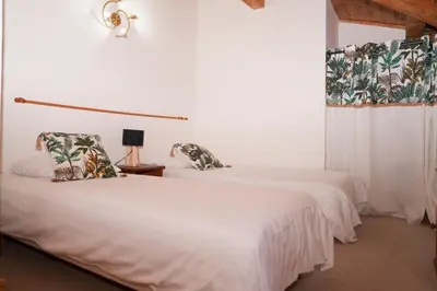 a bedroom with a bed and a desk and a window at Fontaine du Mont Blanc Hotel & Spa in Les Houches