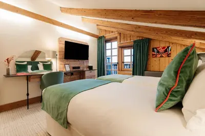 a bedroom with a large bed and a television at La Ferme du Golf in Megève