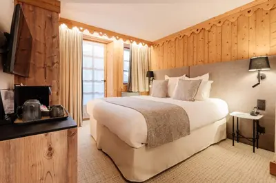 a bedroom with a large bed in a room with wooden walls at La Ferme du Golf in Megève