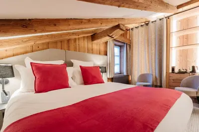 a bedroom with two beds and a desk in a room at La Ferme du Golf in Megève