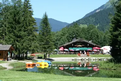 a building with a lake in front of it at Les Jardins Alpins - Apartment in Saint-Gervais-les-Bains