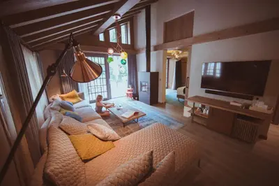 a living room with a couch and a tv at Le Hameau Albert 1er - Relais & Châteaux in Chamonix-Mont-Blanc