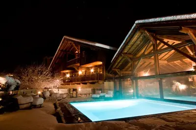a house with a swimming pool at night at Le Hameau Albert 1er - Relais & Châteaux in Chamonix-Mont-Blanc