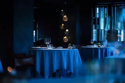 two tables in a restaurant with wine glasses on them at Le Hameau Albert 1er - Relais & Châteaux in Chamonix-Mont-Blanc