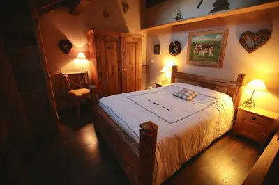 a bedroom with a bed with a white bedspread at Duplex en vieux bois hyper centre in Chamonix-Mont-Blanc